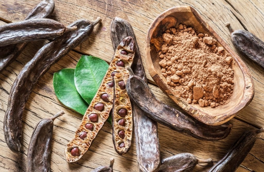 gousses de caroube et poudre utilisées comme alternative au cacao en pâtisserie