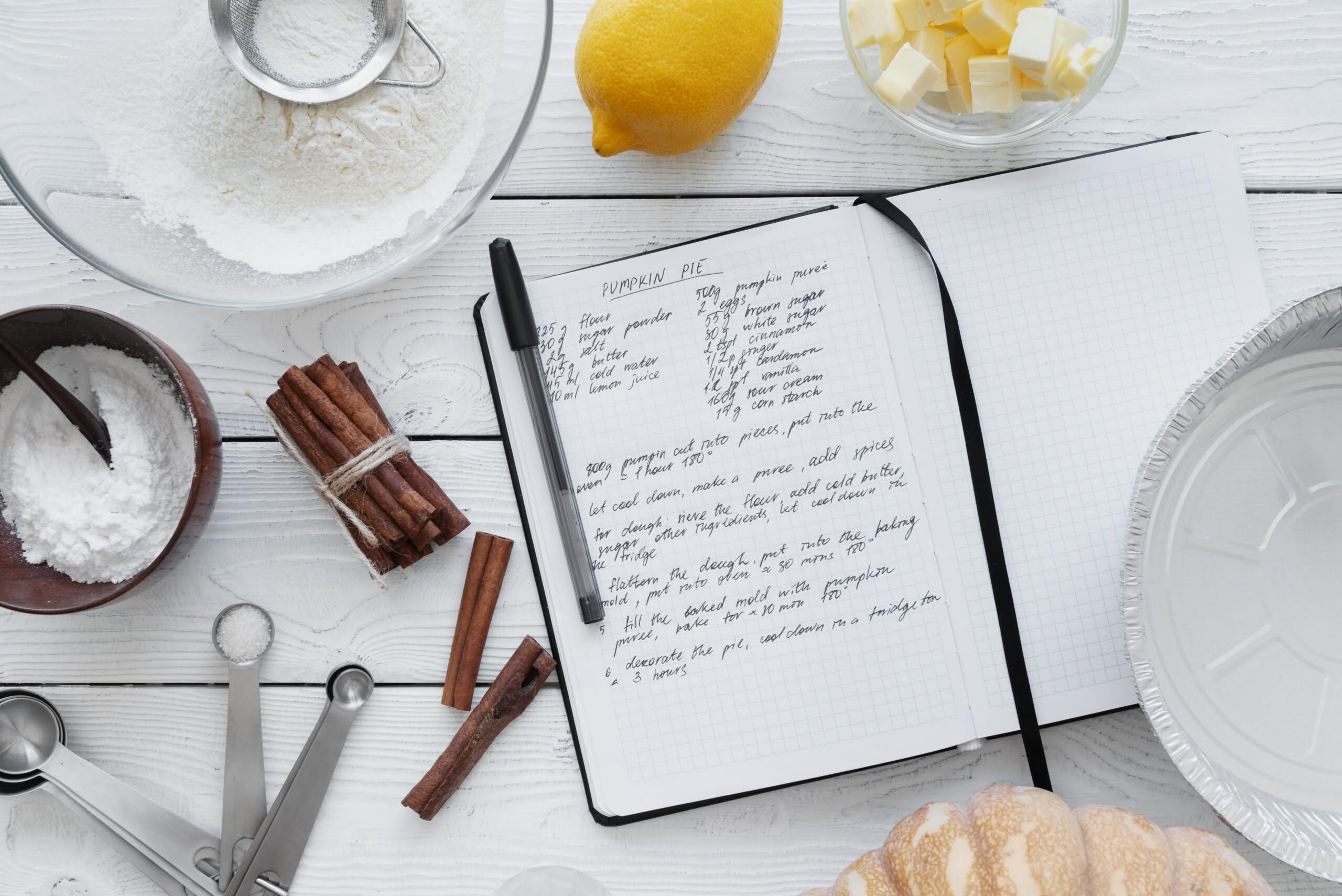 carnet de recette entouré d’ingrédients illustrant la reformulation en pâtisserie face à la pénurie d’œufs